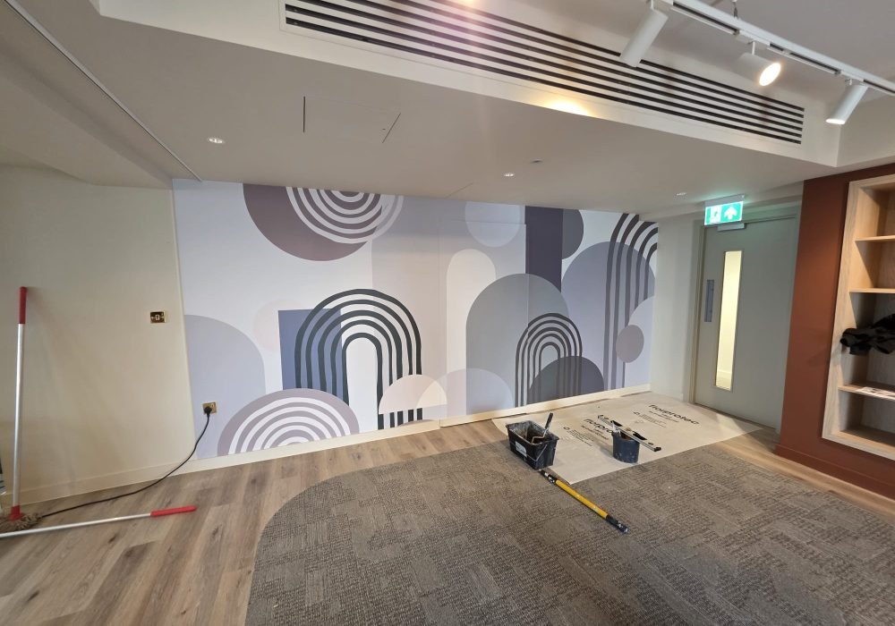 Office wall with painted geometric mural during commercial decorating works