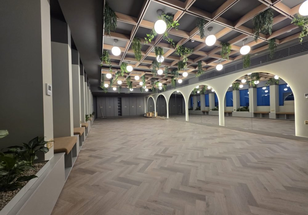 Open-plan commercial office after painting and decorating, with arched alcoves and wood flooring
